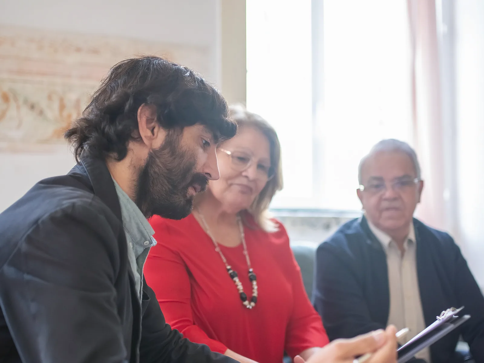 Advisor discussing documents with an older couple during a planning meeting