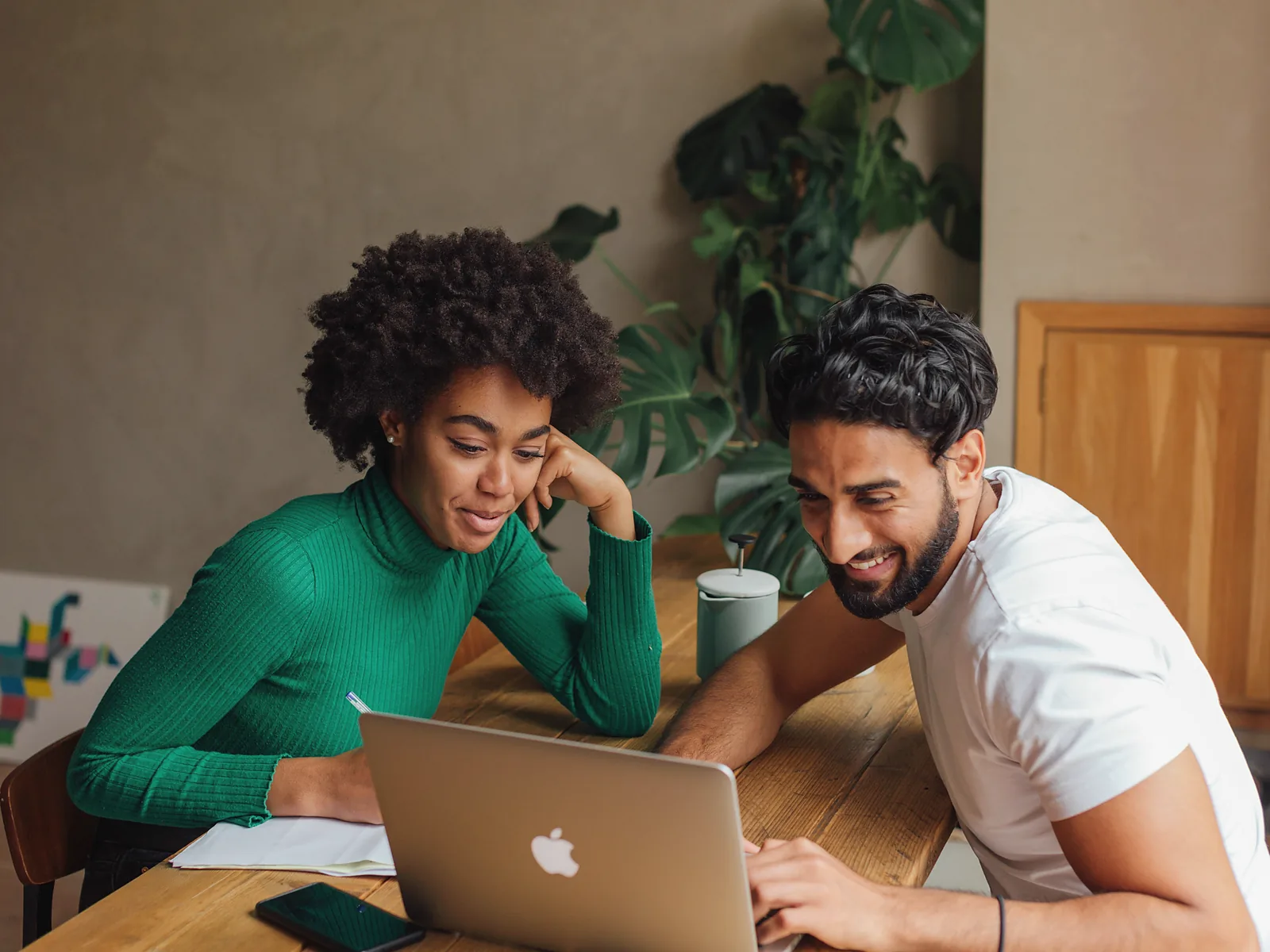 Two professionals reviewing a workflow together on a laptop