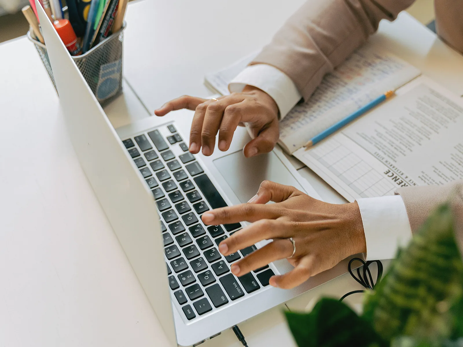 Professional typing a client follow-up email beside printed notes