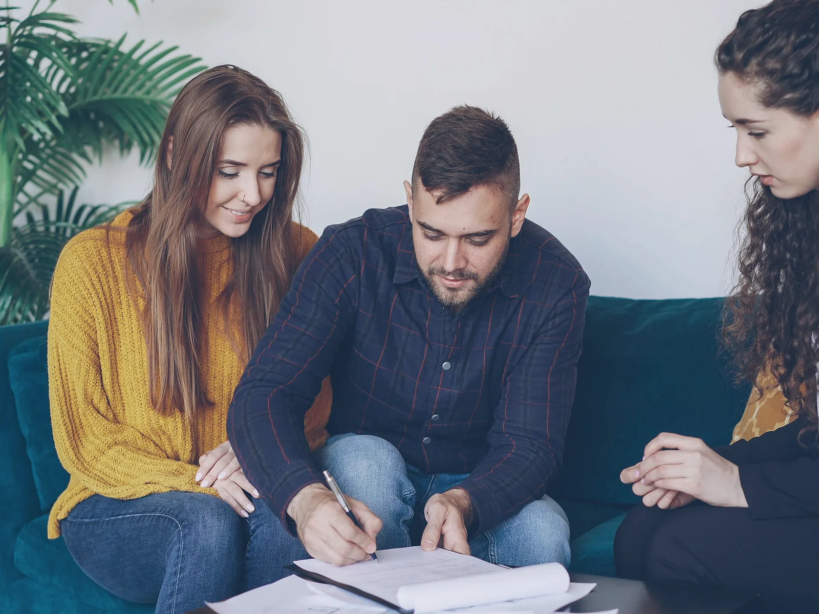 Client signing paperwork while an advisor guides the process