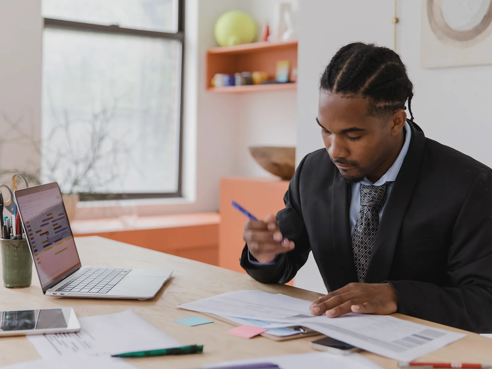 Financial professional reviewing client documents beside an open laptop